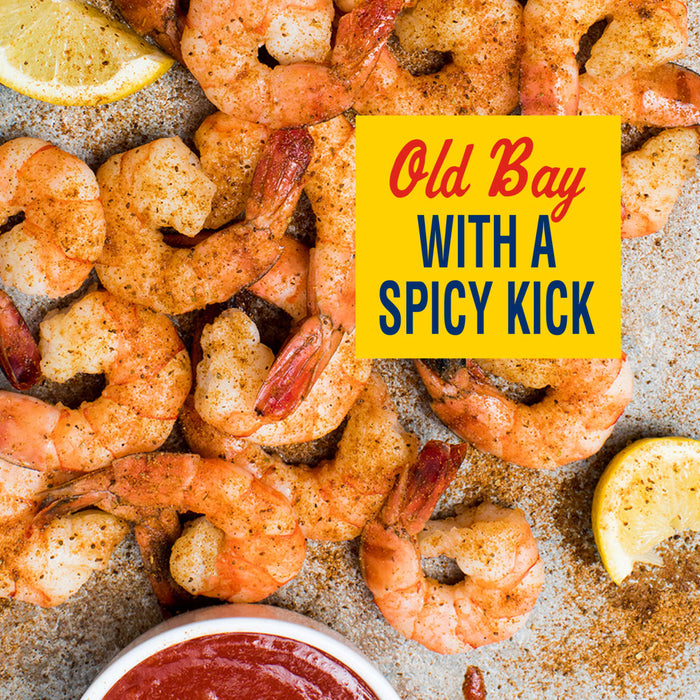 A close-up of Old Bay seasoned shrimp with a spicy kick, served with lemon wedges and cocktail sauce.