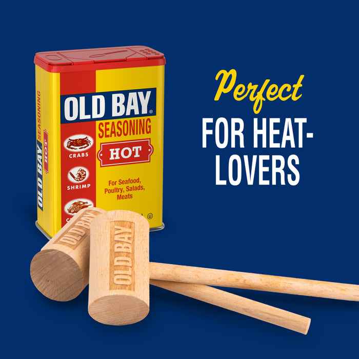 A can of Old Bay Hot Seasoning is displayed with wooden mallets, advertising it as perfect for heat-lovers.