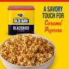 A bowl of caramel popcorn is dusted with Old Bay Black Bird Seasoning, 6.5 Oz next to the yellow and purple Baltimore Ravens themed tin.