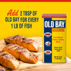 A container of Old Bay Seasoning next to grilled salmon fillets.