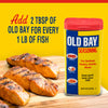 A container of Old Bay Seasoning next to grilled salmon fillets.