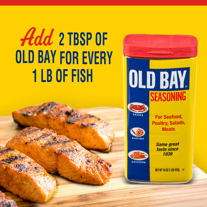 A container of Old Bay Seasoning next to grilled salmon fillets.