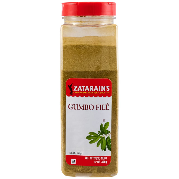 A clear plastic container of Zatarains Gumbo File Seasoning Ground 12 Oz is shown, featuring a red cap and the Zatarain's label over the greenish-brown powder inside.