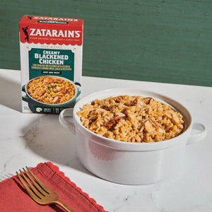 A box of Zatarain's Creamy Blackened Chicken with a bowl of the prepared dish.