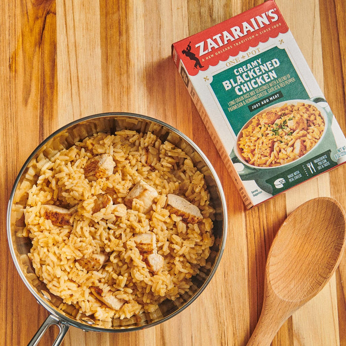 A bowl of Zatarain's Creamy Blackened Chicken with a wooden spoon on a wooden surface.