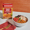 A bowl of Zatarain's Taco Rice with grilled chicken, black beans, tomatoes, and cilantro.