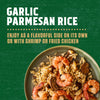 A rustic bowl filled with Zatarain'S Garlic Parmesan Long Grain White Rice, 6.9 Oz, mixed with shrimp and mushrooms, is presented as a delicious serving suggestion.