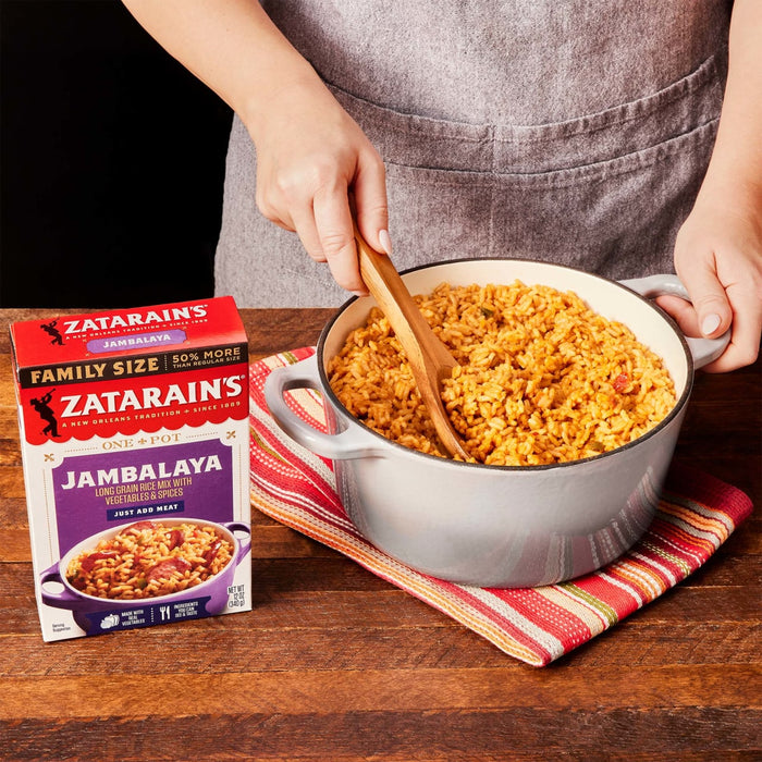 A person is holding a pot of Zatarains Jambalaya a long grain rice mix with vegetables and spices.