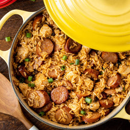 A yellow pot filled with jambalaya a Cajun and Creole dish made with rice chicken sausage and vegetables.