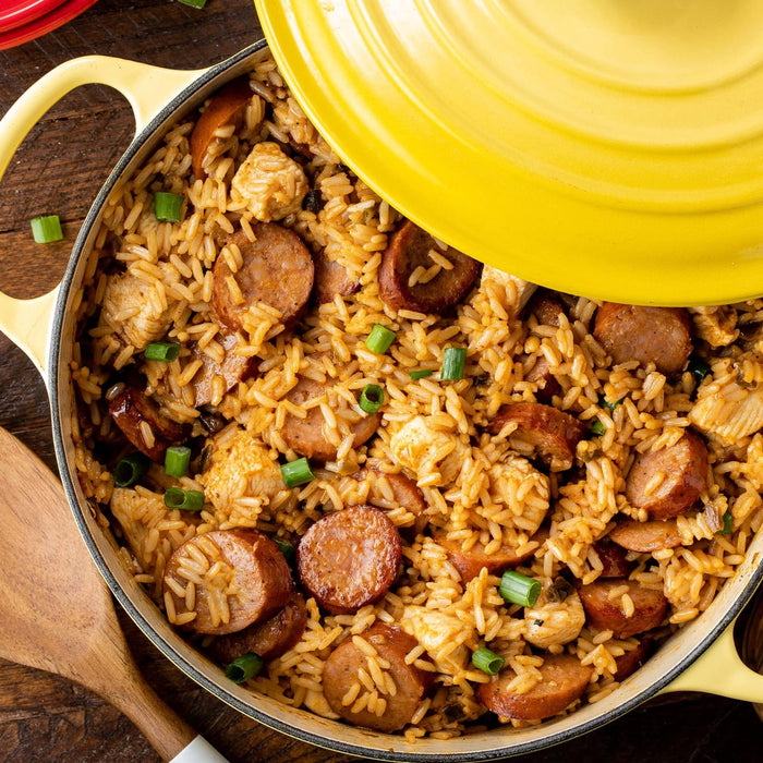 A yellow pot filled with jambalaya a Cajun and Creole dish made with rice chicken sausage and vegetables.