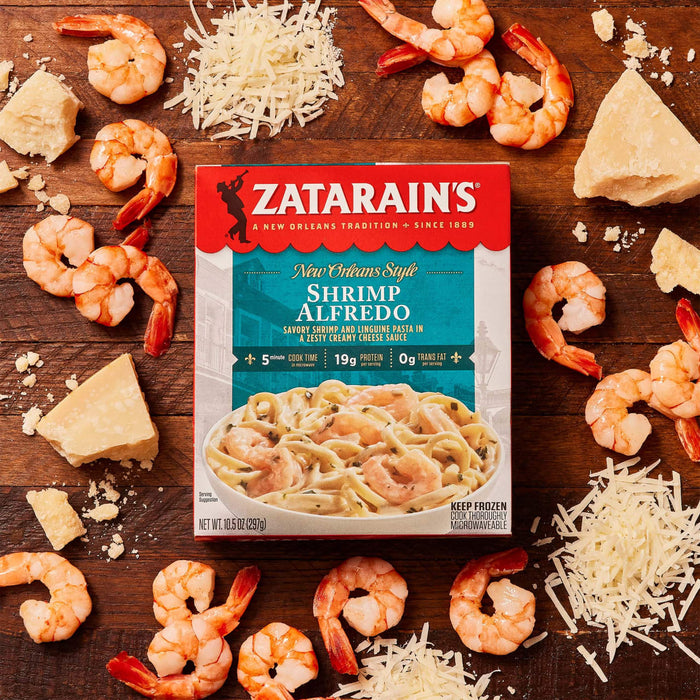 A box of Zatarain's New Orleans Style Shrimp Alfredo with shrimp and parmesan cheese on a wooden table.