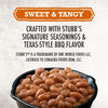 A close-up of Stubb'S Original Baked Beans, Canned Beans, 15.5 Oz., 12-Count in a cast-iron skillet, with text above highlighting the sweet and tangy Texas-style BBQ flavor.