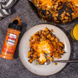 A plate of RedHot Buffalo Seasoning Blend with a side of hash browns and eggs.