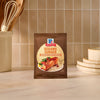 A packet of Mccormick Sesame Ginger All Purpose Sauce Mix Envelope 1 Oz sits on a kitchen counter, ready to create a quick and flavorful meal.