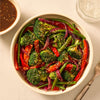 A colorful stir-fry of broccoli, red bell peppers, and green beans is served in a white bowl, a delicious meal that can be made with the Mccormick Sesame Ginger All Purpose Sauce Mix Envelope 1 Oz.
