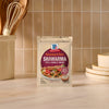 A packet of Mccormick Regular Sauce And Seasoning Mix Envelope 1.37 Oz for Shawarma is placed on a kitchen counter, ready for use.