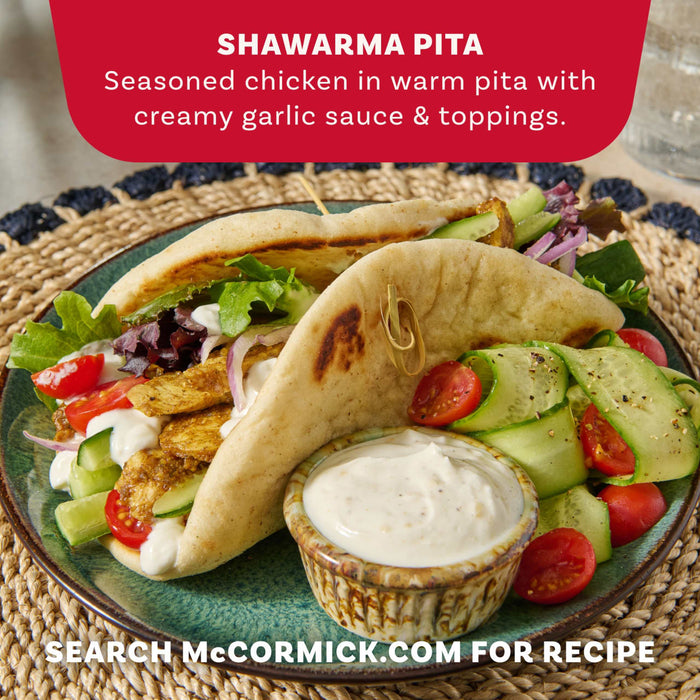 A serving suggestion for the Mccormick Regular Sauce And Seasoning Mix Envelope 1.37 Oz shows two delicious chicken shawarma pitas filled with fresh vegetables and a creamy garlic sauce.