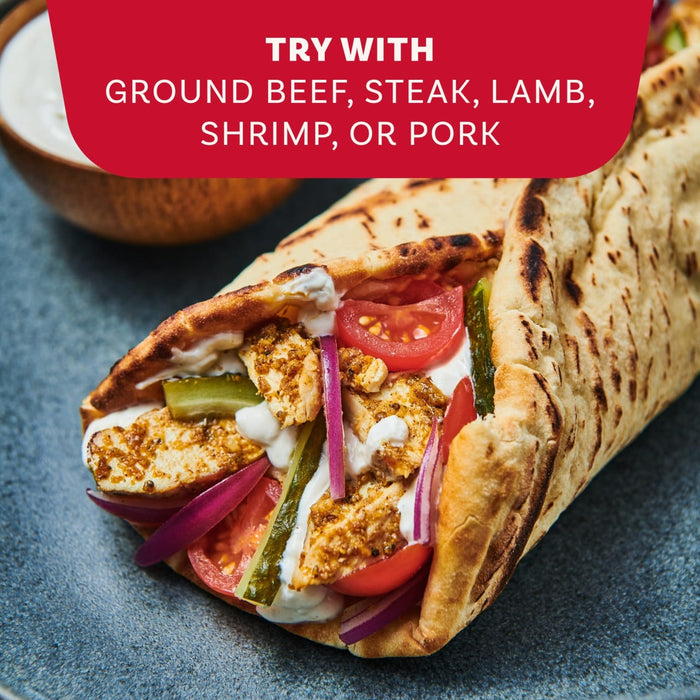 A close-up of a delicious gyro filled with seasoned meat and fresh vegetables, showing a serving suggestion for the Mccormick Regular Sauce And Seasoning Mix Envelope 1.37 Oz.