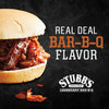 A sandwich with pulled pork and barbecue sauce on a white bun with the words Real Deal Bar-B-Q Flavor and the Stubb\s logo.