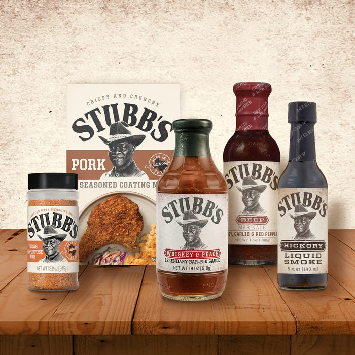 A selection of Stubb's BBQ sauces and seasonings are displayed on a wooden table.