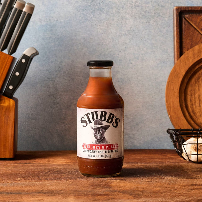A bottle of Stubb's Original Bar-B-Q Sauce sits on a wooden surface.