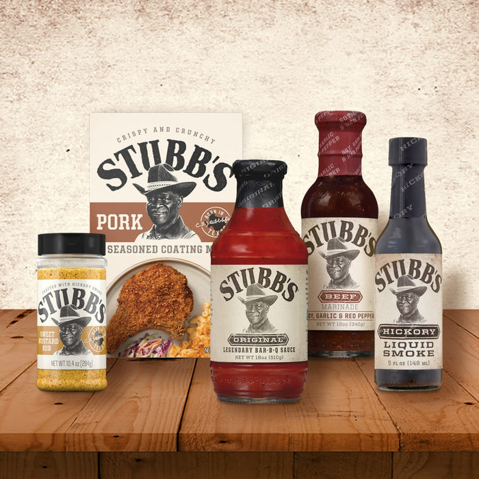 A selection of Stubb's BBQ sauces and seasonings are displayed on a wooden table.