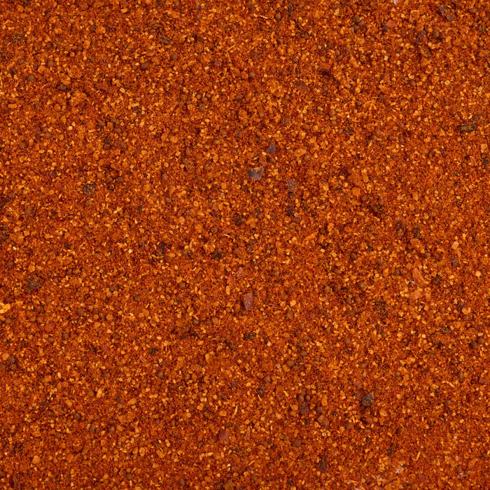 A detailed close up view shows the coarse texture and vibrant orange and red hues of Stubbs Grlc Lime E seasoning blend.