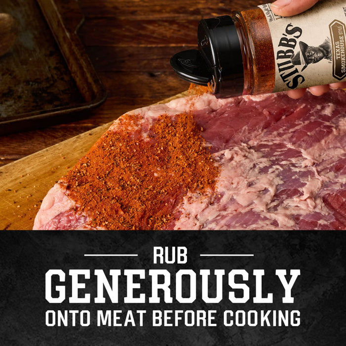 A hand shakes a bottle of Stubbs Smkhouse E seasoning to rub generously onto a large piece of raw meat before cooking.