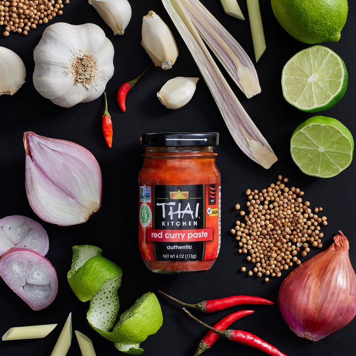 A jar of Thai Kitchen red curry paste with various ingredients like limes shallots garlic and chilies.