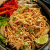 A bowl of Pad Thai noodles with peanuts, red peppers, bean sprouts, and cilantro.