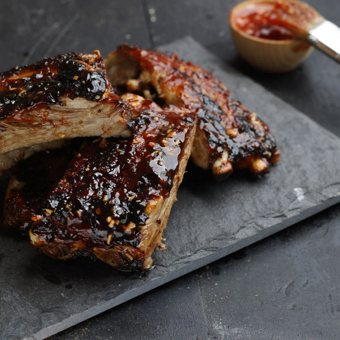 Close up of a plate of glazed pork ribs.