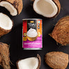 A can of Thai Kitchen Coconut Cream, unsweetened, surrounded by coconut halves.