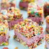 A close-up of colorful cereal treats with pink frosting.