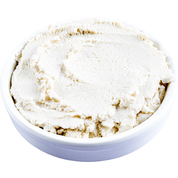 A bowl of creamy, white dip or spread, possibly hummus or a similar dish.