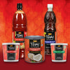A collection of Thai Kitchen products including sweet chili sauce, fish sauce, coconut milk, red curry paste, and green curry paste are displayed against a red background.