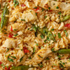 A close-up of a savory Thai chicken and rice dish with snap peas, red peppers, and nuts, made as a serving suggestion for a Thai Kitchen, 9.0 Oz product.