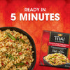 A prepared bowl of chicken and rice sits next to the packaging for Thai Kitchen, 9.0 Oz Coconut Red Curry Sauce with Chicken &amp; Rice, advertising that the meal is ready in 5 minutes.