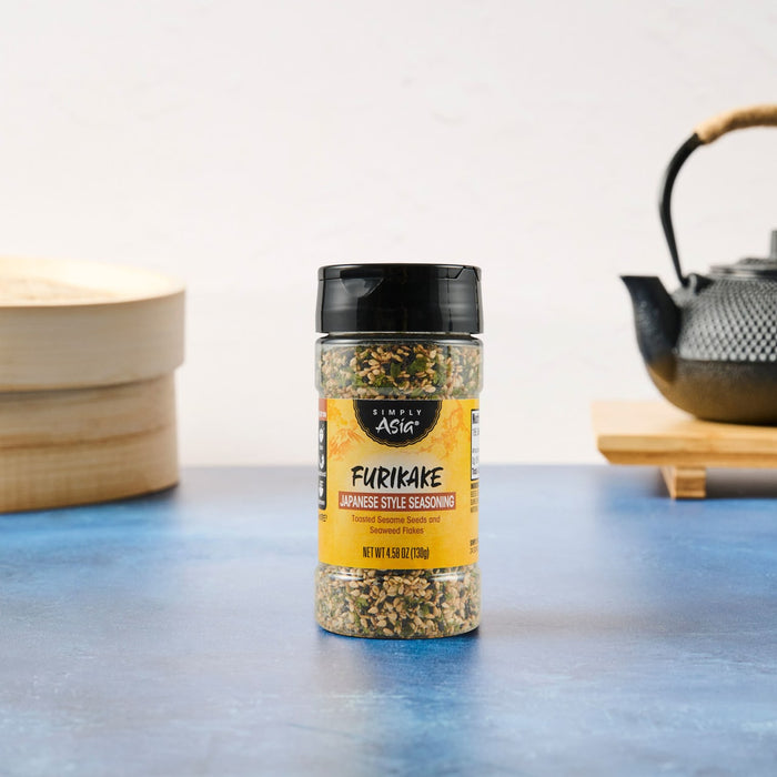 A bottle of Trader Joe's Everything But The Bagel Sesame Seasoning Blend sits on a blue surface.