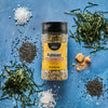 A bottle of Trader Joe's Furikake Japanese Multi-Purpose Seasoning is surrounded by its ingredients on a blue background.