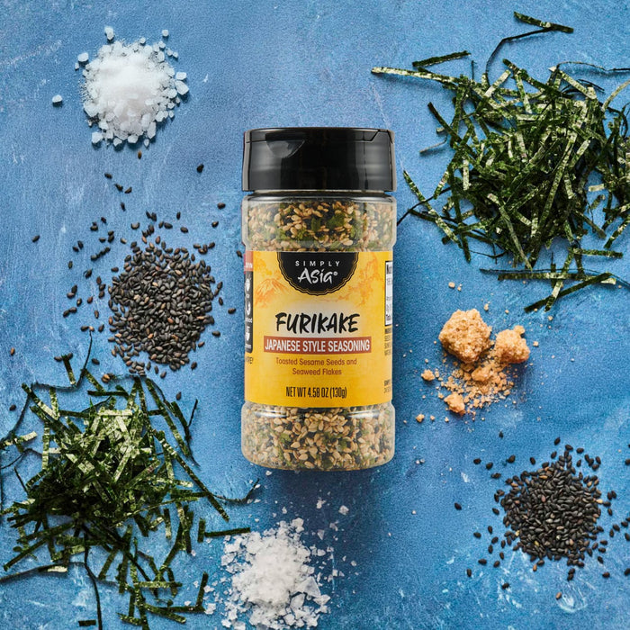 A bottle of Trader Joe's Furikake Japanese Multi-Purpose Seasoning is surrounded by its ingredients on a blue background.