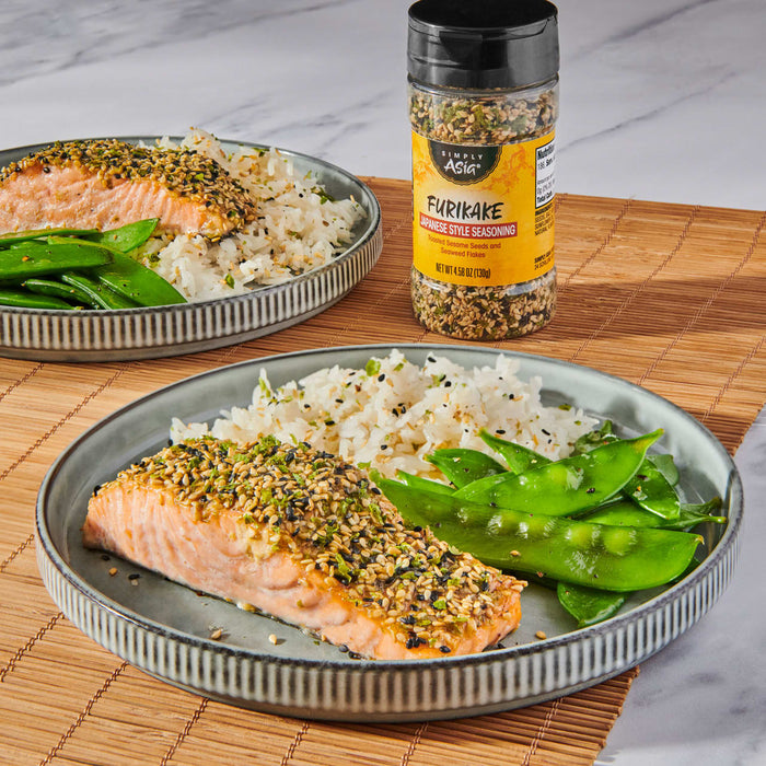 Two plates of salmon seasoned with a McCormick product, served with rice and snow peas.