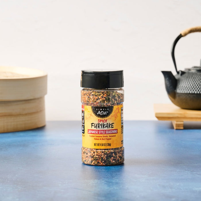 A bottle of Ajinomoto Furikake Japanese seasoning sits on a blue surface.