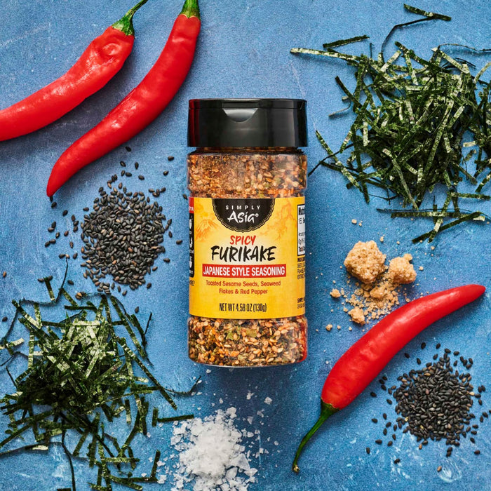 A bottle of Trader Joe's Furikake Japanese Multi-Purpose Seasoning is surrounded by its ingredients, including seaweed, sesame seeds, chili peppers, and salt.