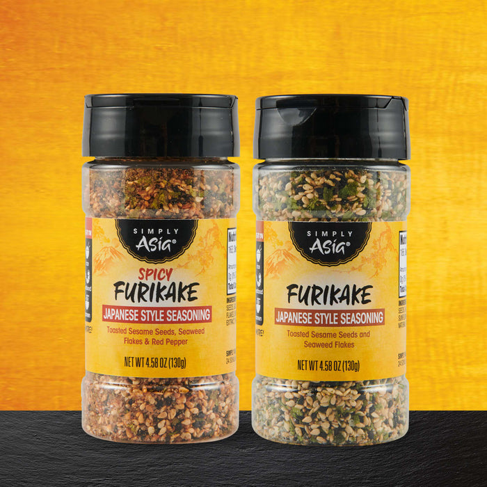 Two containers of First Field Furikake seasoning, one spicy and one original, are displayed against a textured background.