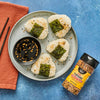 A plate of onigiri seasoned with Trader Joe's Everything But the Bagel Sesame Seasoning Blend, served with a dipping sauce.