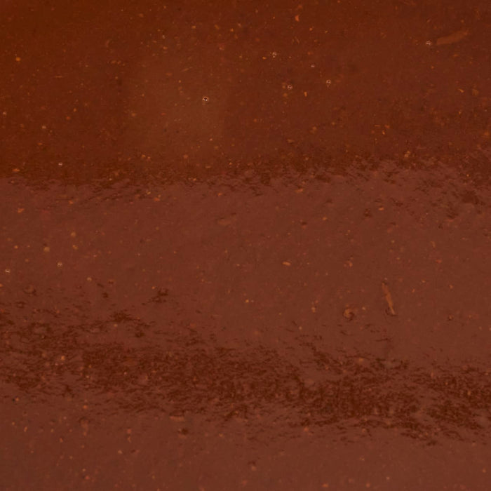 A close-up of a brown liquid with a grainy texture.