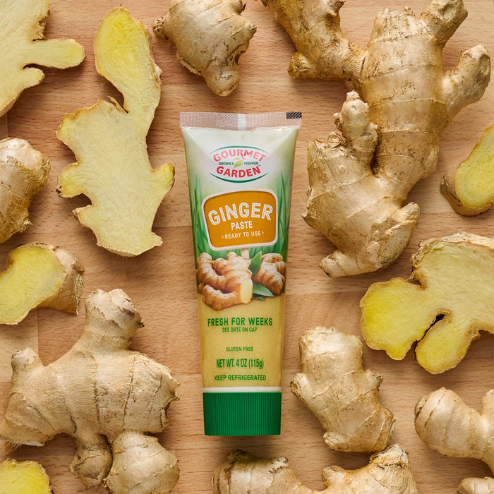 Gourmet Garden Ginger Paste tube surrounded by fresh ginger root.