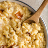 A close-up of a bowl of macaroni and cheese with bacon.