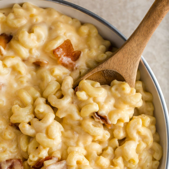 A close-up of a bowl of macaroni and cheese with bacon.