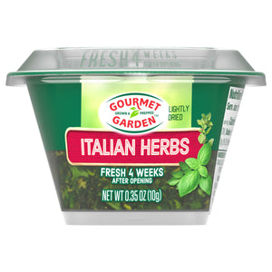 A clear plastic container of Gourmet Garden Italian Herb Seasoning Chopped .35 Oz is shown, with a green label and the lightly dried herbs visible inside.